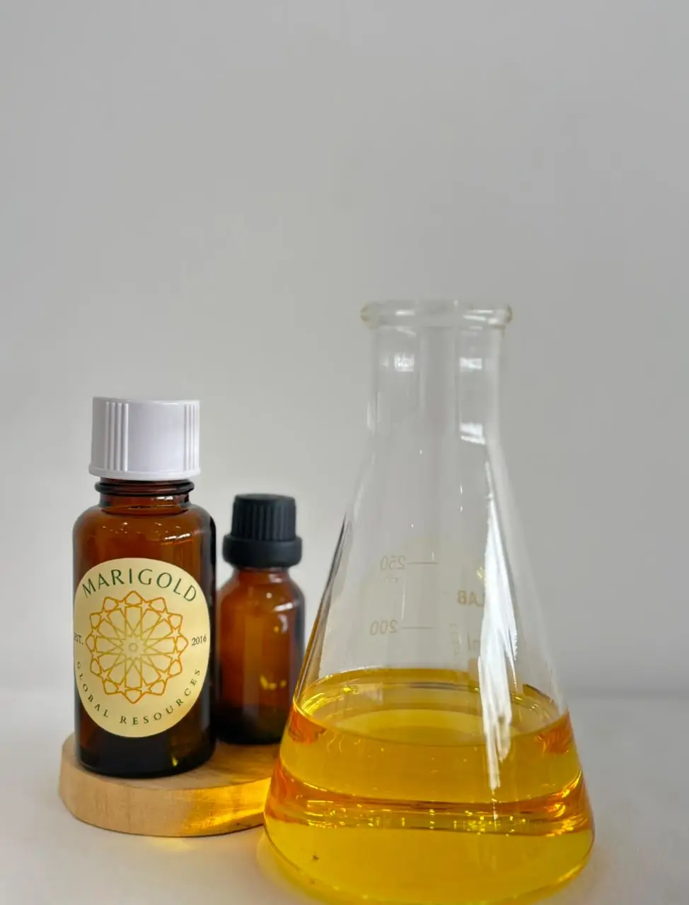 Marigold Indian sandalwood essential oil in an amber bottle beside a flask