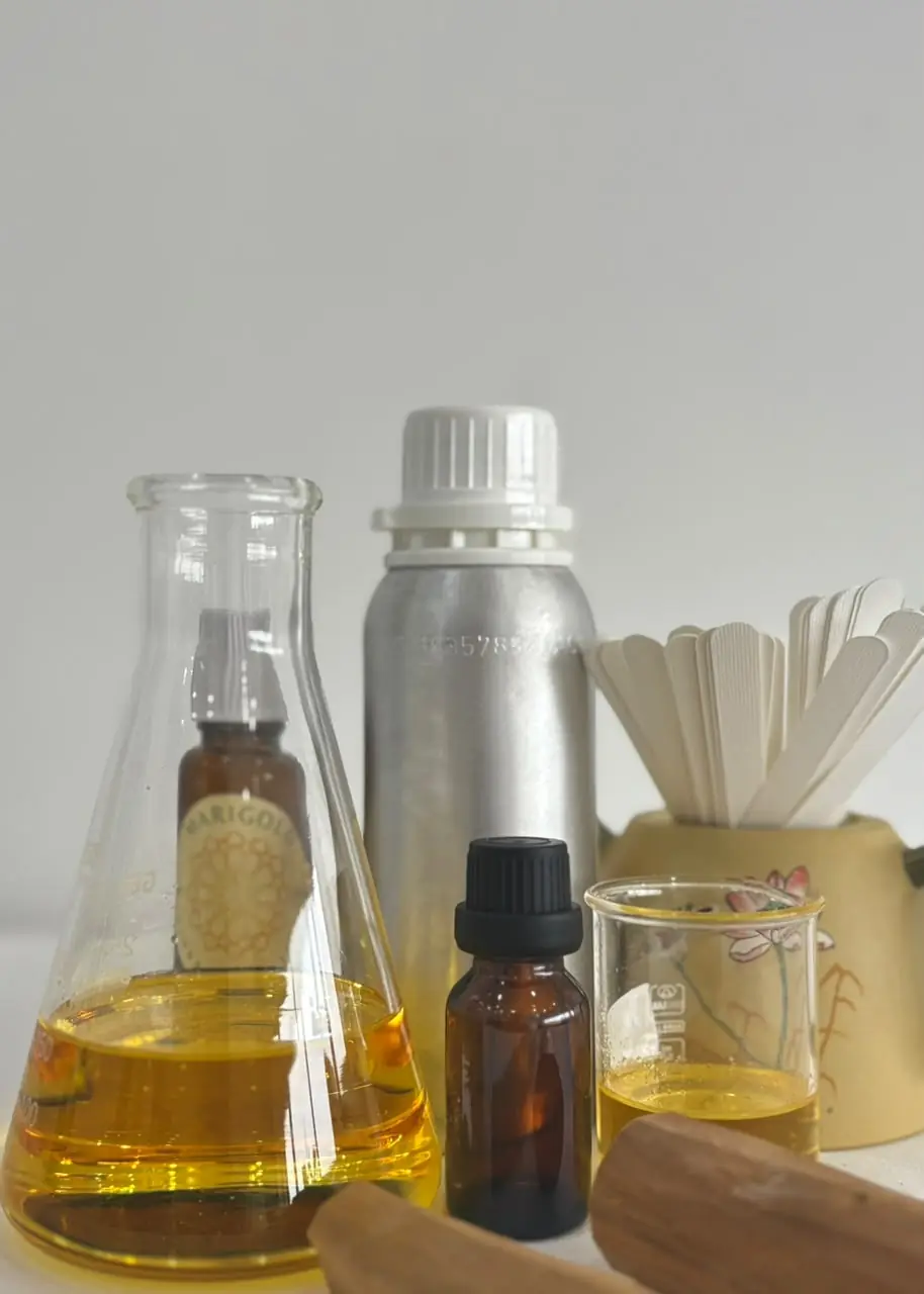 Australian sandalwood essential oil in laboratory glassware beside an aluminium bottle and smelling strips